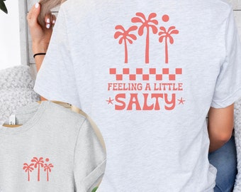 May include: Gray t-shirt with a pink palm tree graphic and the text "Feeling a little *SALTY*" on the back. The front of the shirt has a smaller pink palm tree graphic.