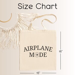 May include: A white canvas tote bag with black text that reads "AIRPLANE MODE" and a small airplane icon. The bag is 15 inches wide and 16 inches tall.