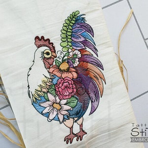 May include: Embroidered design of a rooster with a colorful floral pattern. The rooster is white with a red comb and wattle, and the flowers are in shades of pink, purple, blue, and yellow.