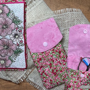 Puede incluir: Tres estuches de tela para gafas y un estuche a juego. Los estuches son en tonos rosa y verde. Un estuche tiene un estampado floral, y los otros dos son de color rosa liso. El estuche más grande tiene un diseño floral bordado.
