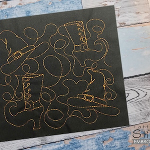 Puede incluir: Una tela negra con bordado dorado de cuatro botas y sombreros de bruja. El diseño es caprichoso y divertido.