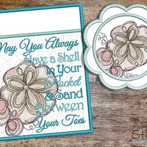 May include: Embroidered artwork with a beach theme. The design features a seashell and the text "May You Always Have a Shell in Your Pocket & Sand Between Your Toes." The artwork is framed in a teal border and includes a matching coaster.