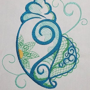 May include: A blue and green seashell with a floral design. The seashell is embroidered with intricate details and swirls.