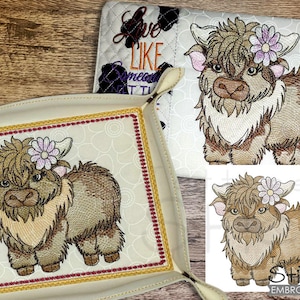 May include: Embroidered design of a brown and white Highland cow with a pink flower on its head. The design is on a white background with a yellow border.