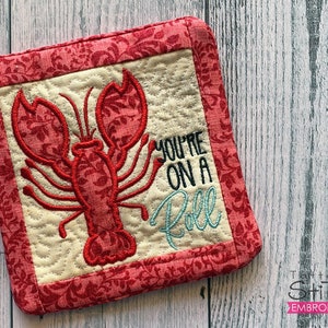 May include: Red and white pot holder with an embroidered lobster and the text "You're on a Roll".