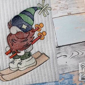 May include: Embroidered design of a gnome wearing a green and blue hat, a brown beard, and skiing down a hill on skis.