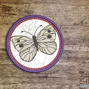 May include: A white butterfly with black markings is embroidered on a round white fabric patch. The patch has a purple and red border.