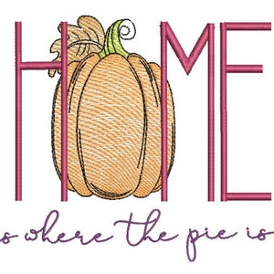 Może przedstawiać: Haftowany wzór z napisem "HOME" z dynią w środku i tekstem "is where the pie is" poniżej. Napis "HOME" jest różowy, a dynia i tekst poniżej są fioletowe.