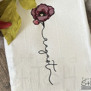 Könnte beinhalten: Stickerei einer einzelnen rosa Blume mit Stiel und dem Wort "August" vertikal in einer kursivschriftlichen Schrift.