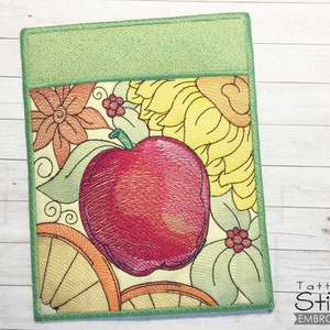 Peut inclure: Motif brodé représentant une pomme rouge, des fleurs jaunes et orange et des feuilles vertes sur un fond crème. Le motif est entouré d'une bordure verte.