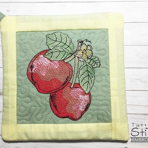 May include: Embroidered square pot holder with a light green background and a yellow border. The center features two red apples with green leaves and a small yellow flower. A green loop is attached for hanging.