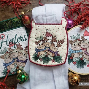 Könnte beinhalten: Bestickte Weihnachts-Küchenhandtuch mit einem rot-weißen Design mit einer Gruppe von drei Cartoon-Rentieren mit dem Text "HOHO Heifers" auf einem grün-weißen Hintergrund.