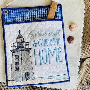 May include: A white quilted pot holder with blue trim features an embroidered lighthouse with the text "So shine a light & guide me home".