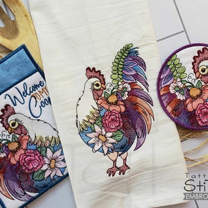 Puede incluir: Toalla de cocina bordada con un diseño de gallo. El gallo está rodeado de flores y tiene un cuerpo blanco con plumas de colores. La toalla tiene el texto "Bienvenido a mi gallinero" bordado.