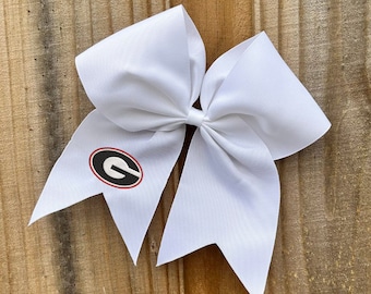 May include: White cheer bow with a red and black University of Georgia 'G' logo.