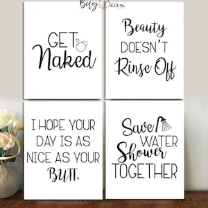 May include: Four white bathroom art prints with black text. The prints read: "GET Naked", "Beauty Doesn't Rinse Off", "I Hope Your Day Is As Nice As Your Butt", and "Save Water Shower Together".