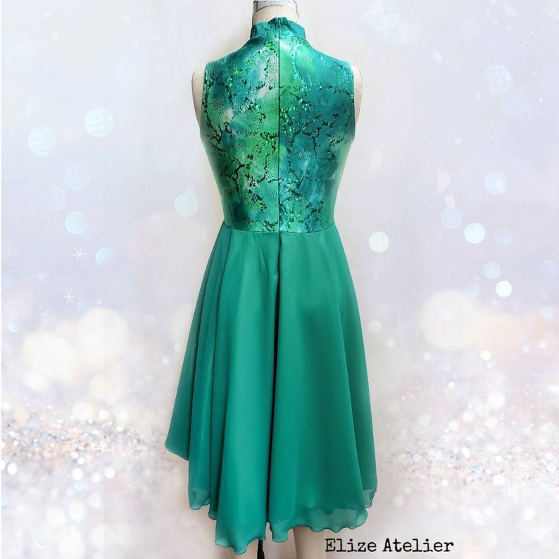 Puede incluir: Un vestido verde sin mangas con cuello alto y un corpi&ntilde;o estampado. La falda es de tejido de gasa fluido.