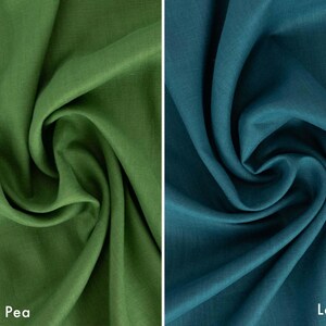 May include: Two swatches of fabric, one in a vibrant green labeled "Sweet Pea" and the other in a deep teal labeled "Lagoon." The fabric is draped, showcasing its texture and color variations. Ideal for textiles and crafting.