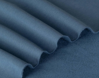 Op de afbeelding: Close-up van een blauwe stof met een zachte, pluche textuur. De stof is gevouwen om de verschillende lagen te laten zien.