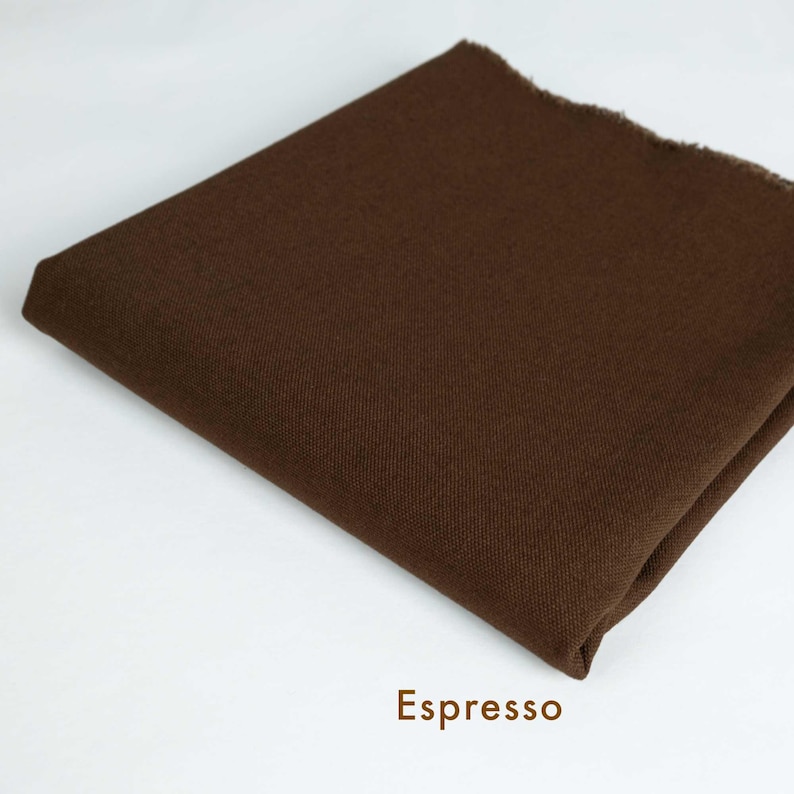 May include: A close-up of a brown fabric swatch. The fabric has a smooth, even texture. The swatch is labeled "Espresso".