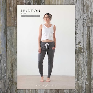 May include: A woman wearing a white tank top and gray sweatpants with a drawstring. The text "HUDSON PANT sewing pattern | sizes 0-18" and "TRUE/BIAS" are visible on the image.
