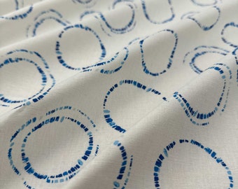 Puede incluir: Tela blanca con un diseño estampado azul de pequeños círculos. Los círculos están formados por pequeños puntos azules.