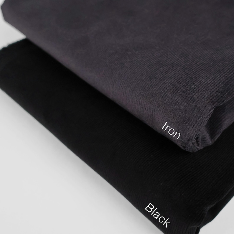 May include: Two fabric swatches, one black and one iron, with the color names written below each swatch.