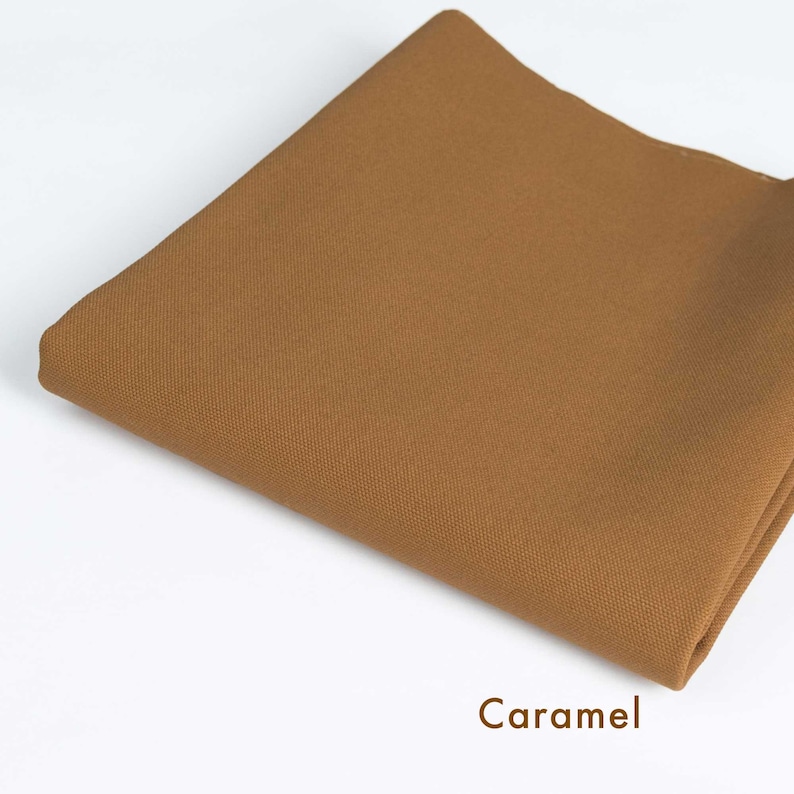 May include: A caramel colored fabric swatch. The fabric has a smooth, even texture.