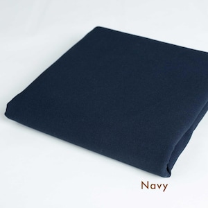 May include: A folded piece of navy blue fabric. The fabric is smooth and has a slight sheen.