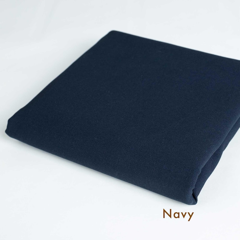 May include: A folded piece of navy blue fabric. The fabric is smooth and has a slight sheen.