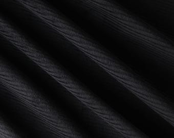 May include: Black ribbed fabric with a smooth, textured surface. The fabric is folded and draped, creating a soft, flowing look.
