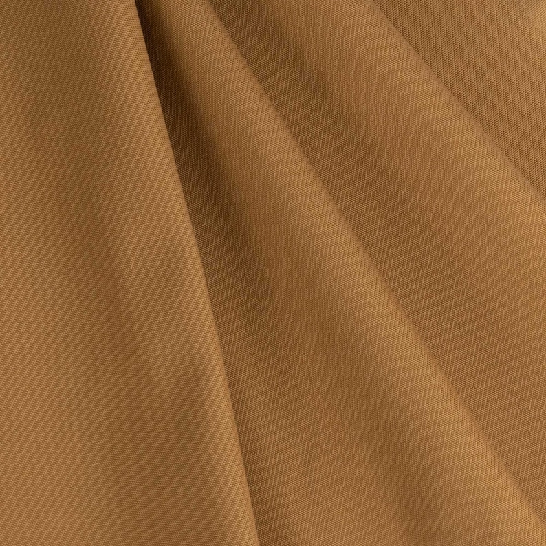 May include: A close-up of a brown fabric with a smooth texture. The fabric is folded in a way that creates a soft, flowing drape.