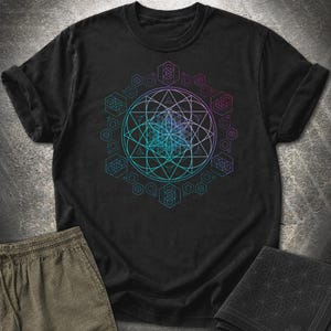 May include: A black short-sleeve t-shirt featuring a large, intricate geometric design on the chest. The graphic consists of a central flower of life pattern surrounded by interconnected circles, triangles, and hexagons in gradient shades of blue, purple, and teal.