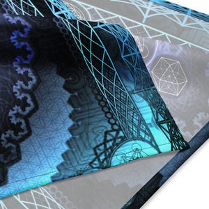 May include: A close-up of a blue and black patterned fabric with geometric designs. The fabric is folded over, showing the stitching along the edge.