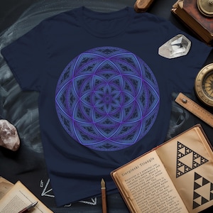 Peut inclure: T-shirt bleu marine avec un motif fractal géométrique violet et bleu. Le motif est centré. Un livre ouvert avec le texte "Sierpinski Triangle" est visible.