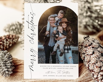 May include: A Christmas card with a photo of a family of four. The card has a white background with black text that reads "merry christmas" and "WISHING YOU A WONDERFUL HOLIDAY SEASON FILLED WITH JOY, LAUGHTER AND LOVE with love, The Smithas JOHN, AMANDA, WILLIAM AND THOMAS".