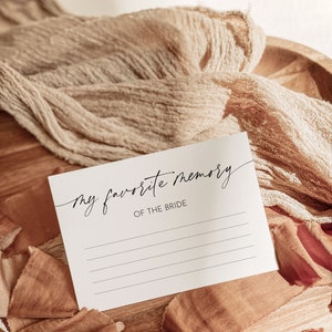 May include: A white card with the text "my favorite memory of the bride" written in black cursive. The card has lines for writing on it.
