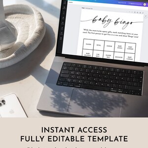 May include: A laptop computer displaying a printable baby bingo game card. The card has a white background with black text and includes items like diaper, bowl, onesie, baby shoes, baby carrier, baby blanket, car seat, diaper bag, bouncer, and baby carrier. The text on the card reads "baby bingo" and "While the mom-to-be opens gifts, mark matching items on your card. The first person to get five in a row and shout 'Bingo' wins!"