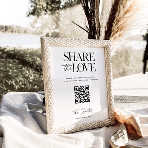May include: A white sign with a black frame and a black and white QR code. The sign reads "Share the Love" and "Please share your photos with us. Scan with your smartphone and upload." The sign also includes the text "The Smiths" and "September 10, 2017".