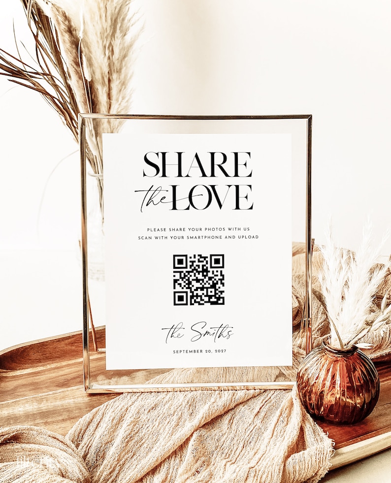 May include: A white sign with black text that reads "SHARE the LOVE" and a QR code. The text below the QR code reads "PLEASE SHARE YOUR PHOTOS WITH US SCAN WITH YOUR SMARTPHONE AND UPLOAD" and "The Smiths SEPTEMBER 20, 2027".