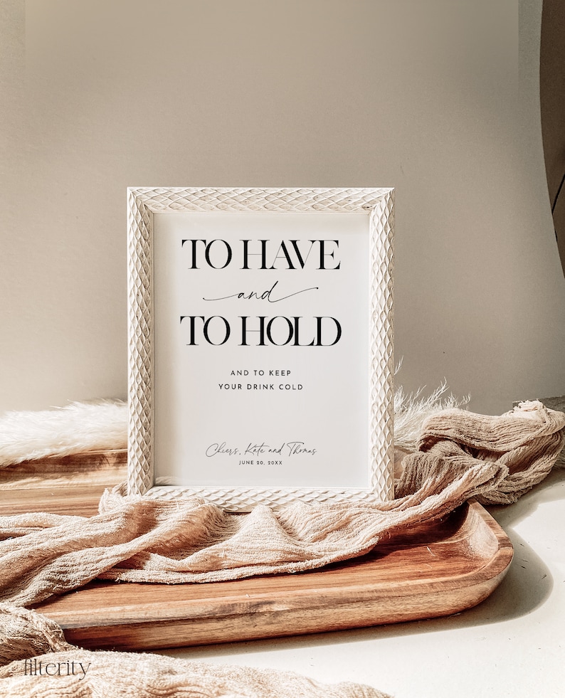 Może przedstawiać: Biały znak z czarnym tekstem, kt&oacute;ry brzmi "To Have and To Hold and to keep your drink cold." Znak zawiera r&oacute;wnież tekst "Cheers, Kate and Thomas June 10, 20XX".