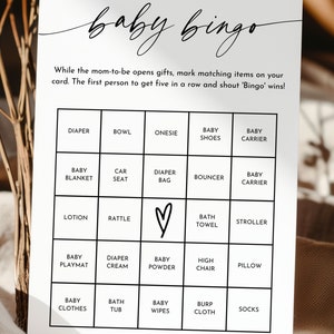 May include: A black and white baby bingo card with a handwritten title. The card has a 5x5 grid with squares containing baby-related items such as a diaper, rattle, baby wipes, and a high chair.