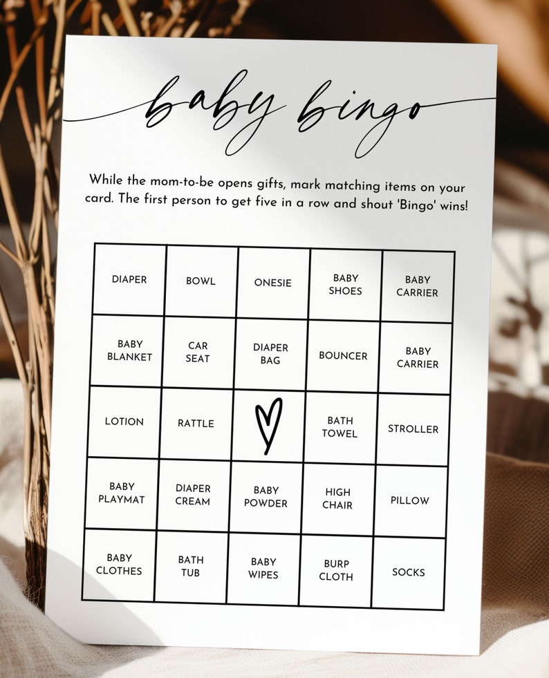 May include: A black and white baby bingo card with a handwritten title. The card has a 5x5 grid with squares containing baby-related items such as a diaper, rattle, baby wipes, and a high chair.