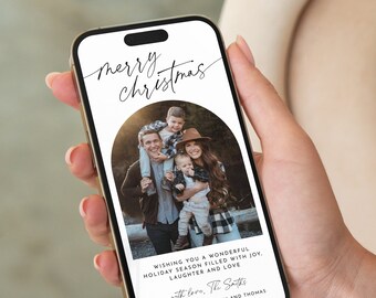 以下が含まれることがあります： デジタル電話の画面に、家族写真が載ったクリスマスカードが表示されています。カードには「merry christmas」と「Wishing you a wonderful holiday season filled with joy, laughter and love. with love. The Smiths John, Amanda, William and Thomas」と書かれています。