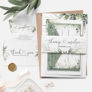 May include: Elegant wedding stationery set featuring botanical illustrations in shades of green and gold. The set includes invitations, RSVP cards, a belly band with the names "Thomas & Caroline", and a thank you card.