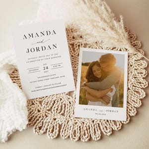 May include: A wedding invitation with a white background and black text. The invitation reads "Amanda and Jordan joyfully invite you to the celebration of their marriage" and includes the date, time, and location of the wedding. A photo of the couple is included on a separate card.