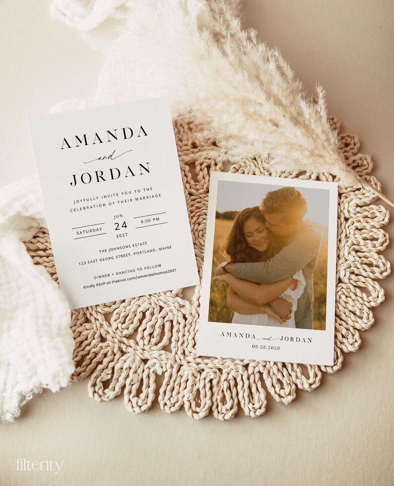 May include: A wedding invitation with a white background and black text. The invitation reads "Amanda and Jordan joyfully invite you to the celebration of their marriage" and includes the date, time, and location of the wedding. A photo of the couple is included on a separate card.