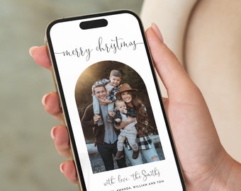 以下が含まれることがあります： クリスマスカードが写っているデジタル携帯電話の画面。カードには4人家族の写真と「メリークリスマス」と「with love, the Smiths, John, Amanda, William and Tom」の文字が書かれている。