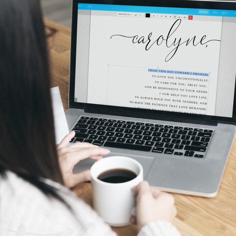 May include: A person using a laptop with the name "carolyne" and a vow displayed on the screen. The person is holding a white mug with a dark liquid. The laptop is on a wooden surface.