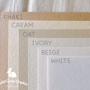 May include: A color chart showing six different shades of paper, from darkest to lightest: khaki, cream, oat, ivory, beige, and white. The paper has a textured surface.